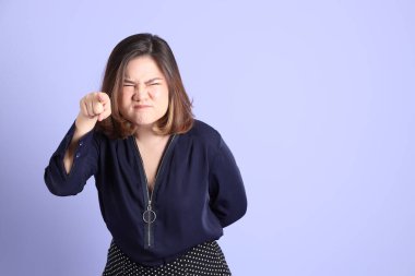 Mor arka planda sıradan kıyafetlerle duran tombul Asyalı kadın..