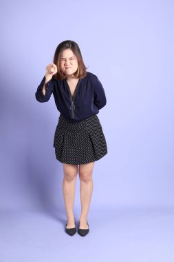 Mor arka planda sıradan kıyafetlerle duran tombul Asyalı kadın..