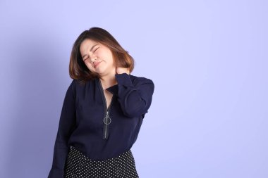 Mor arka planda sıradan kıyafetlerle duran tombul Asyalı kadın..