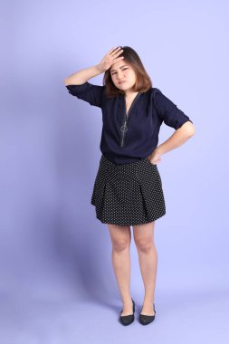 Mor arka planda sıradan kıyafetlerle duran tombul Asyalı kadın..