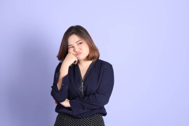 Mor arka planda sıradan kıyafetlerle duran tombul Asyalı kadın..