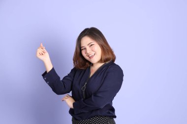 Mor arka planda sıradan kıyafetlerle duran tombul Asyalı kadın..