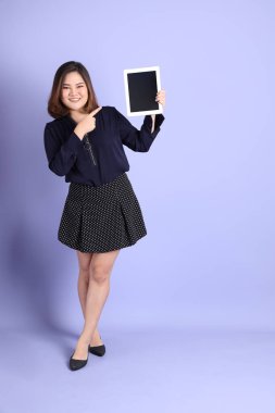 Mor arka planda sıradan kıyafetlerle duran tombul Asyalı kadın..