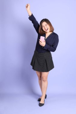 Mor arka planda sıradan kıyafetlerle duran tombul Asyalı kadın..