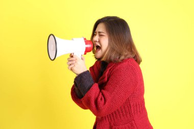 Sarı arka planda sıradan kıyafetlerle duran tombul Asyalı kadın..