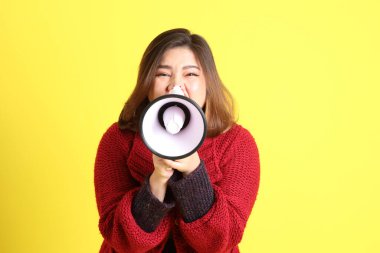 Sarı arka planda sıradan kıyafetlerle duran tombul Asyalı kadın..