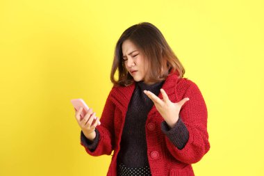 Sarı arka planda sıradan kıyafetlerle duran tombul Asyalı kadın..