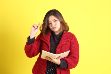 Sarı arka planda sıradan kıyafetlerle duran tombul Asyalı kadın..