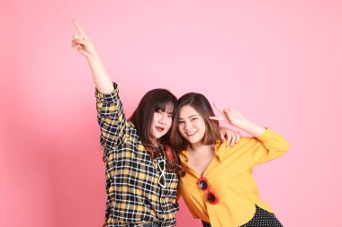 Pembe arka planda duran Asyalı mutlu kardeş..