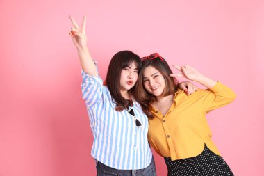 Pembe arka planda duran Asyalı mutlu kardeş..