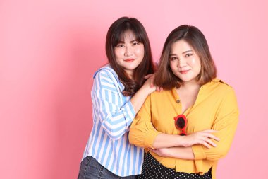 Pembe arka planda duran Asyalı mutlu kardeş..