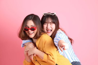 Pembe arka planda duran Asyalı mutlu kardeş..