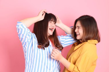 Pembe arka planda duran Asyalı mutlu kardeş..