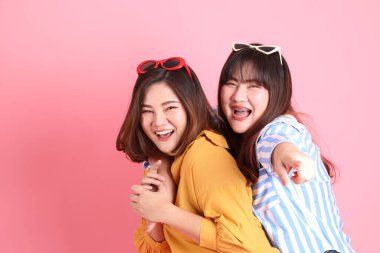 Pembe arka planda duran Asyalı mutlu kardeş..