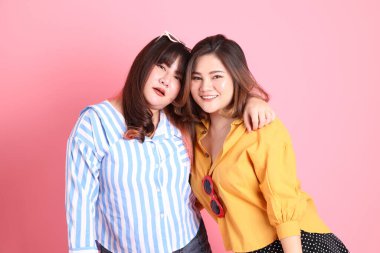 Pembe arka planda duran Asyalı mutlu kardeş..