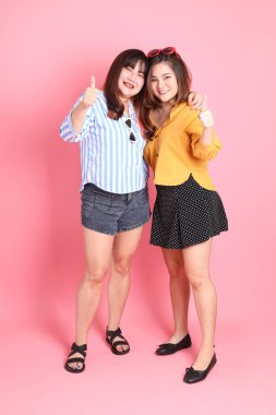 Pembe arka planda duran Asyalı mutlu kardeş..