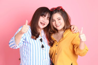 Pembe arka planda duran Asyalı mutlu kardeş..