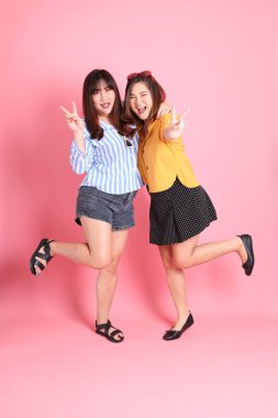 Pembe arka planda duran Asyalı mutlu kardeş..