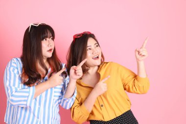 Pembe arka planda duran Asyalı mutlu kardeş..