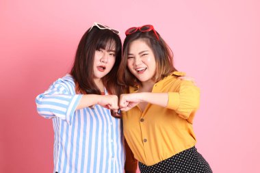 Pembe arka planda duran Asyalı mutlu kardeş..