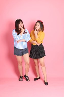 Pembe arka planda duran Asyalı mutlu kardeş..