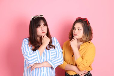 Pembe arka planda duran Asyalı mutlu kardeş..