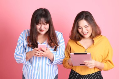 Pembe arka planda duran Asyalı mutlu kardeş..