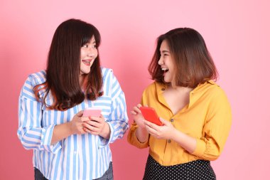 Pembe arka planda duran Asyalı mutlu kardeş..