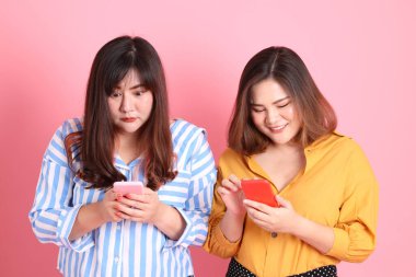 Pembe arka planda duran Asyalı mutlu kardeş..