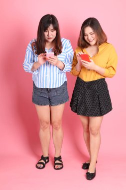 Pembe arka planda duran Asyalı mutlu kardeş..