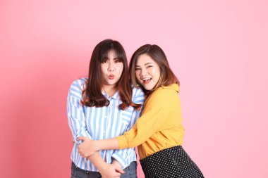 Pembe arka planda duran Asyalı mutlu kardeş..