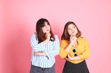 Pembe arka planda duran Asyalı mutlu kardeş..