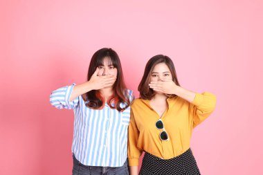 Pembe arka planda duran Asyalı mutlu kardeş..