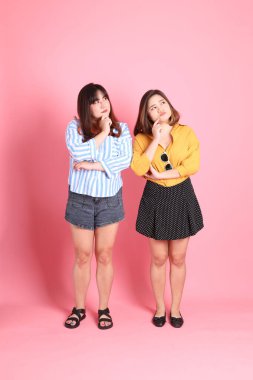 Pembe arka planda duran Asyalı mutlu kardeş..