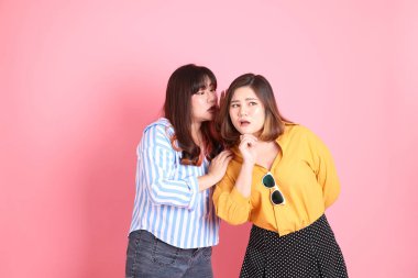 Pembe arka planda duran Asyalı mutlu kardeş..