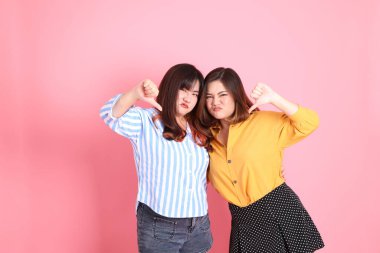 Pembe arka planda duran Asyalı mutlu kardeş..