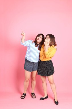 Pembe arka planda duran Asyalı mutlu kardeş..