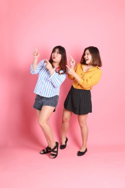 Pembe arka planda duran Asyalı mutlu kardeş..