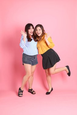 Pembe arka planda duran Asyalı mutlu kardeş..