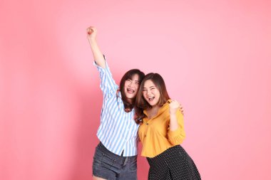 Pembe arka planda duran Asyalı mutlu kardeş..