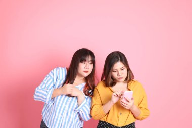 Pembe arka planda duran Asyalı mutlu kardeş..