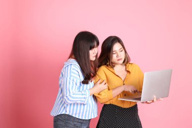 Pembe arka planda duran Asyalı mutlu kardeş..