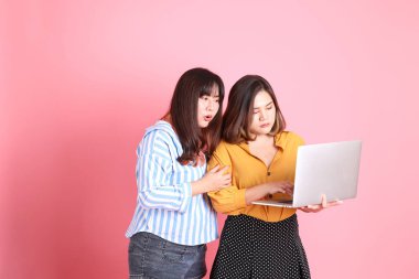 Pembe arka planda duran Asyalı mutlu kardeş..