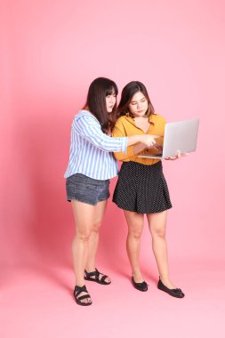 Pembe arka planda duran Asyalı mutlu kardeş..