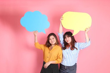 Pembe arka planda duran Asyalı mutlu kardeş..