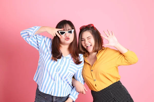 Pembe arka planda duran Asyalı mutlu kardeş..