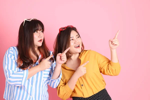 Pembe arka planda duran Asyalı mutlu kardeş..