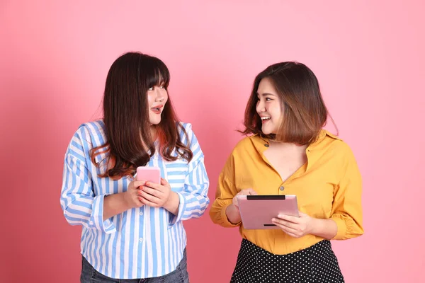 Pembe arka planda duran Asyalı mutlu kardeş..