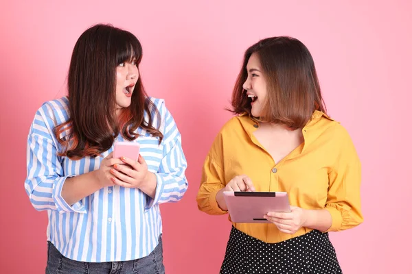 Pembe arka planda duran Asyalı mutlu kardeş..