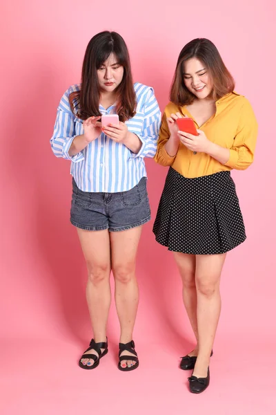 Pembe arka planda duran Asyalı mutlu kardeş..